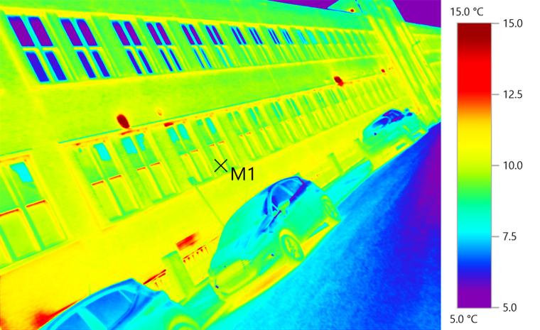 Thermal image &mdash; Commercial fa&ccedil;ade. Glazing units and spandrel panels reading warm against cooler masonry &mdash; typical evidence for a Part L post-construction review.